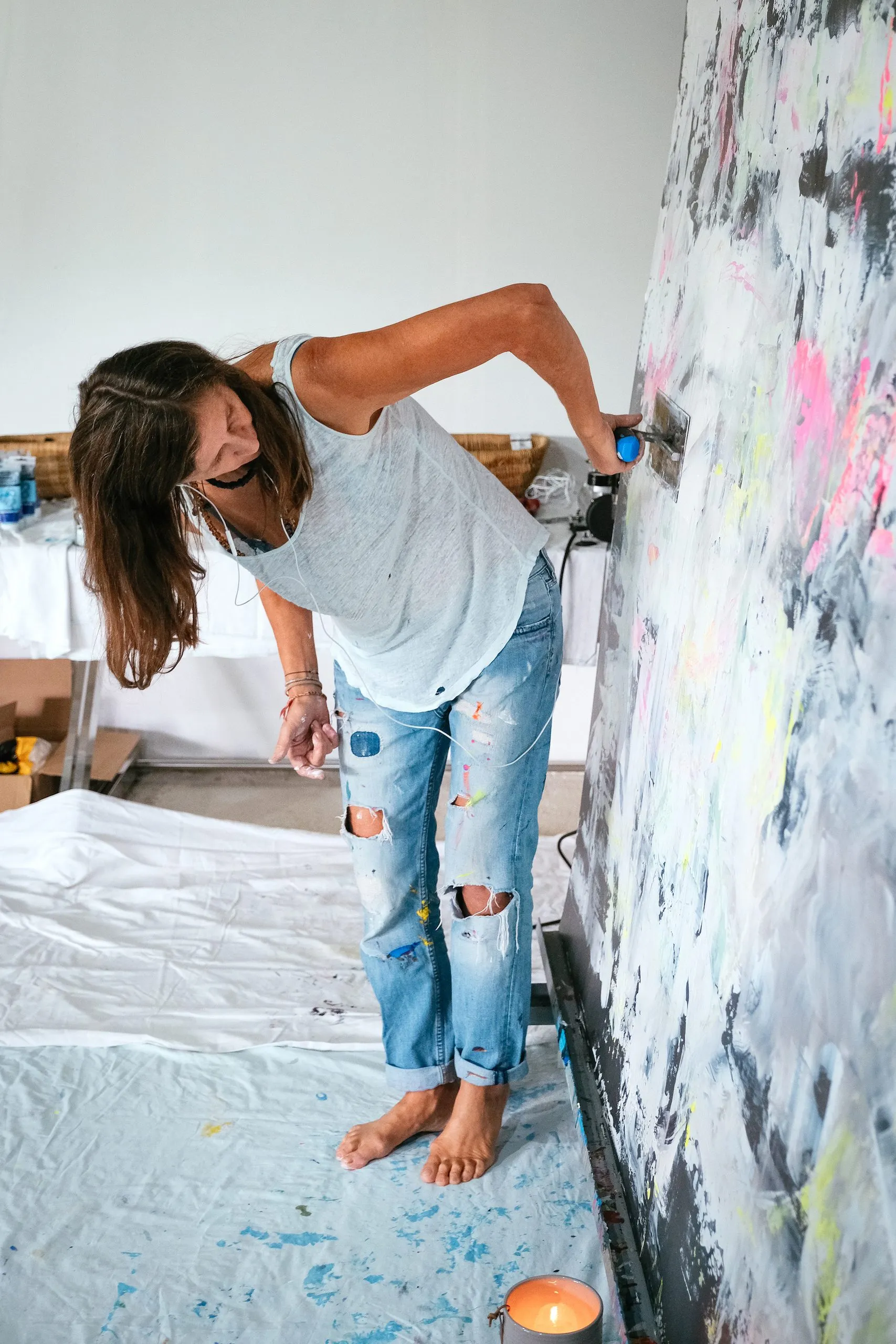 Véronique Massie painting a large metal plate barefoot