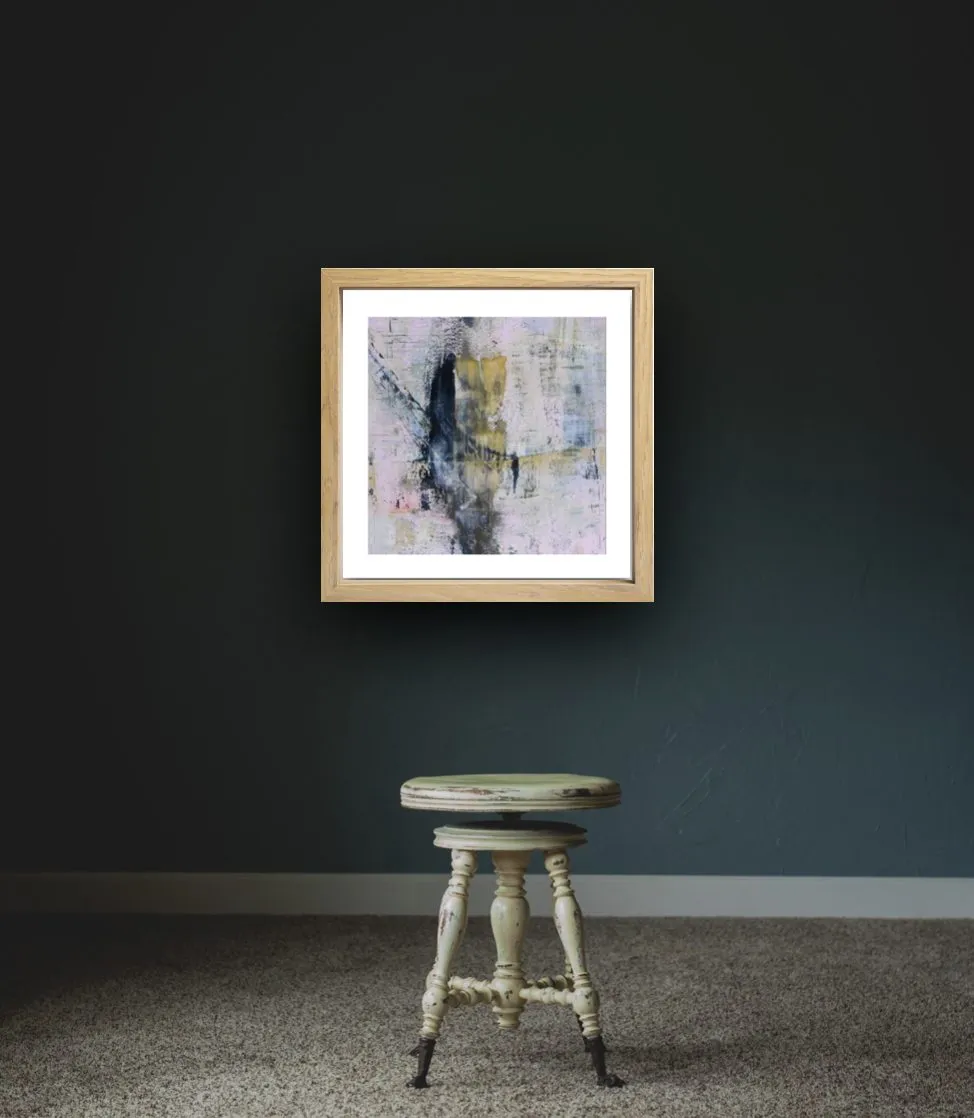 Une édition encadrée, seule sur un mur sombre au-dessus d’un tabouret ancien