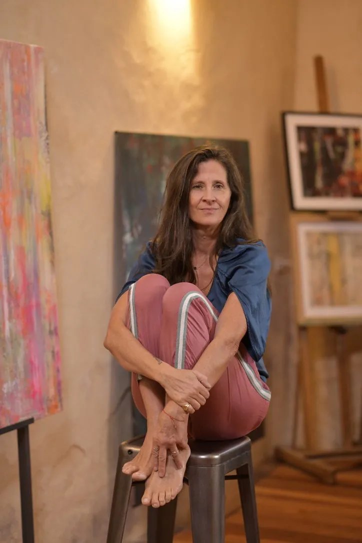 Véronique Massie seated in her studio, surrounded by her works